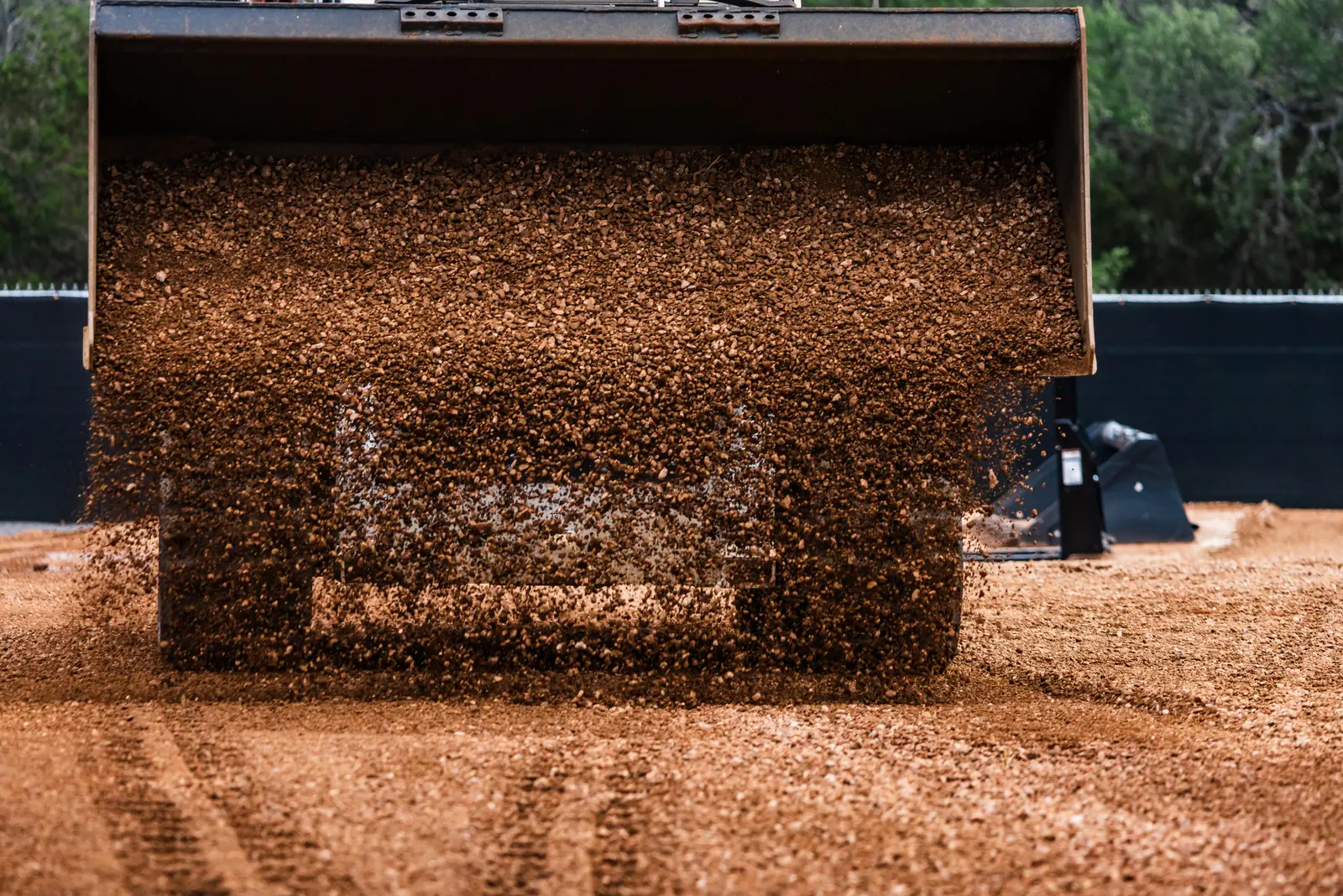 Track loader dropping crushed base