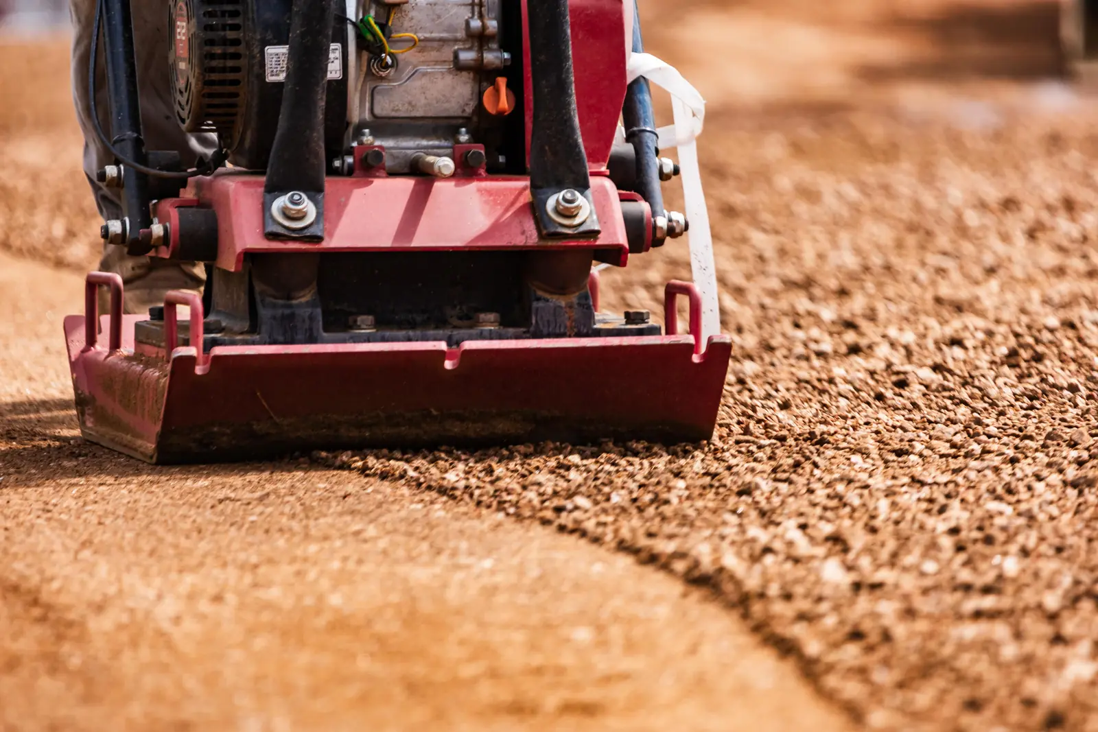 Plate compactor finishing a base course