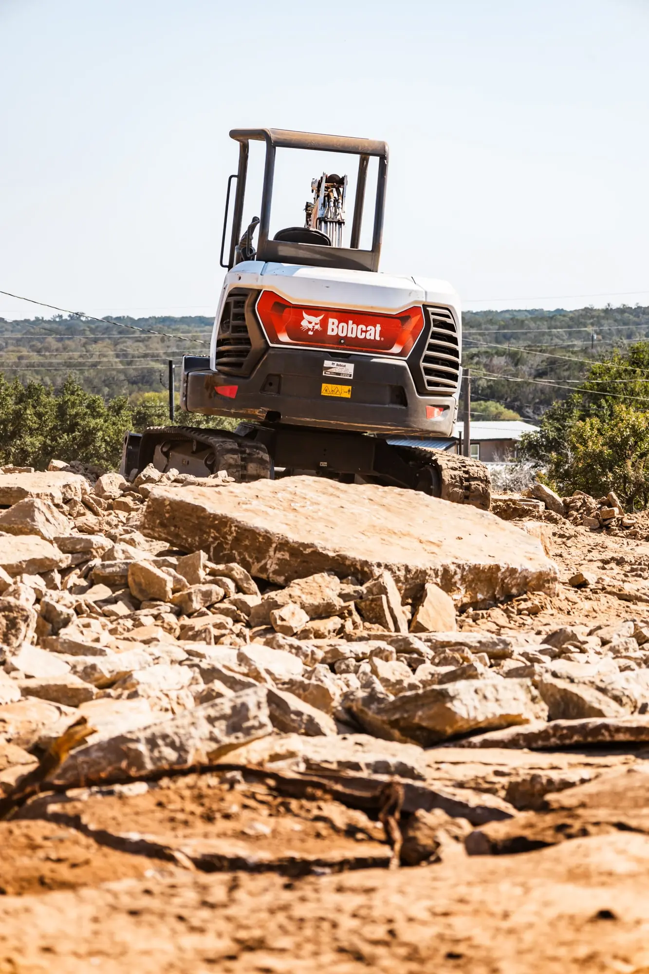 Mini excavator on broken limestone